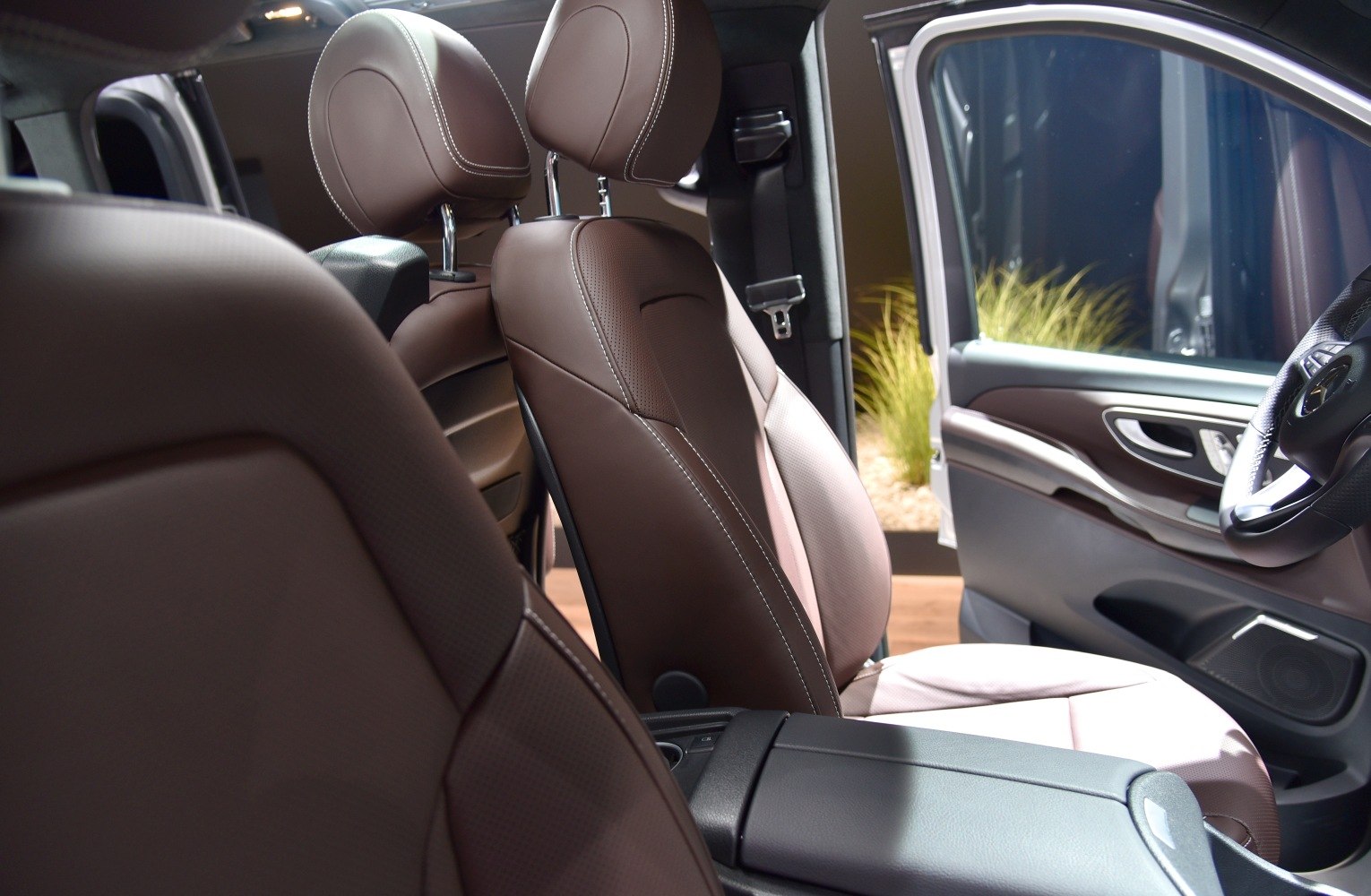 Brown leather seats with detailed stitching and interior armrest