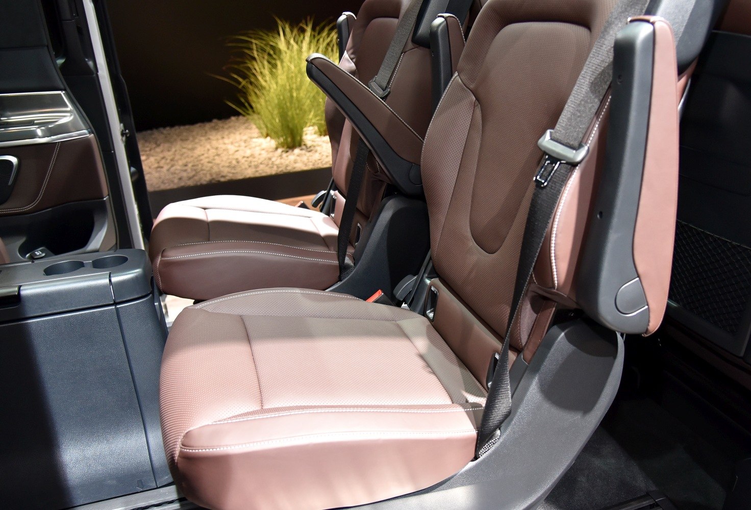 Brown leather car seats with armrests and seatbelts