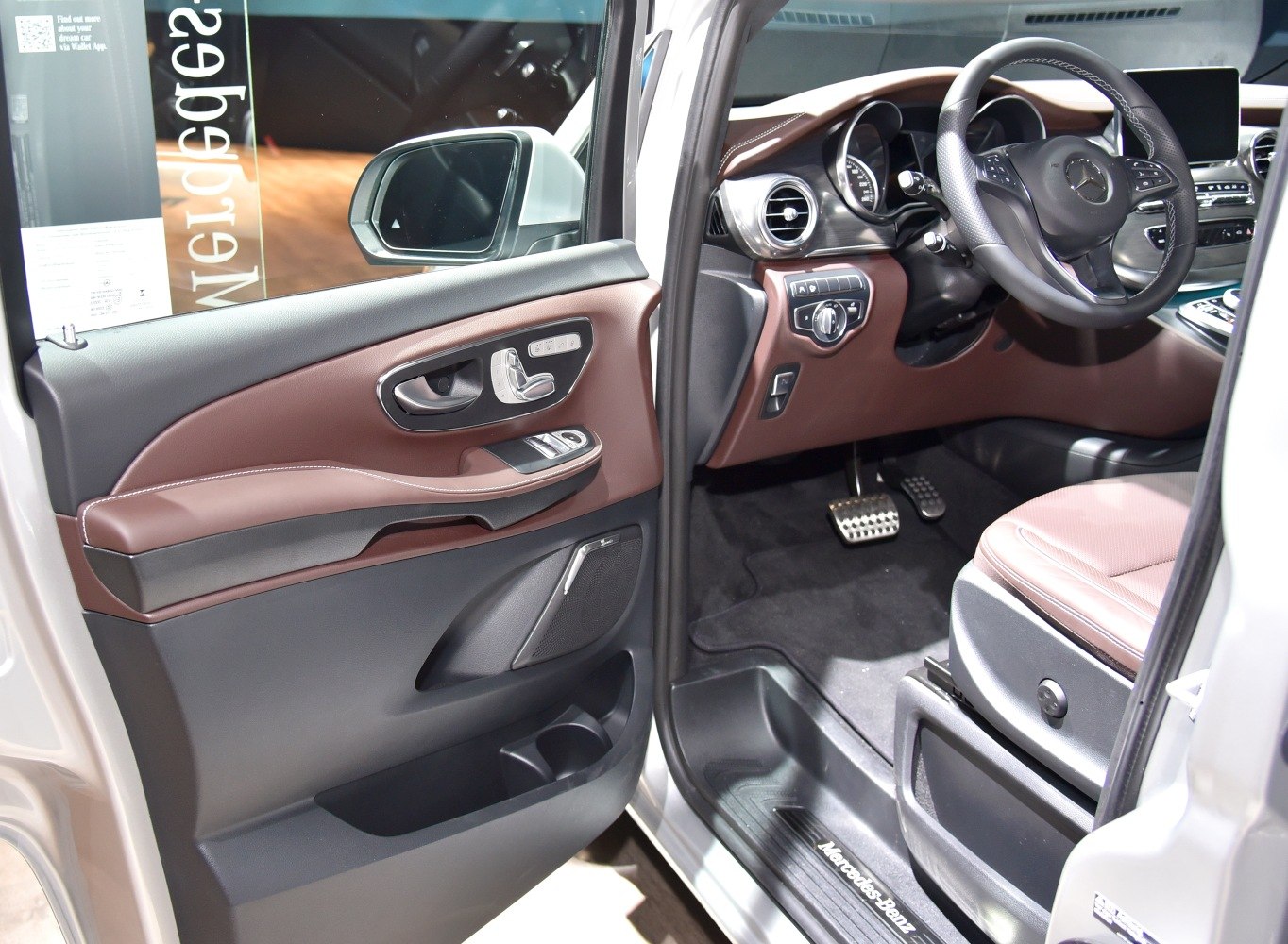 Driver door panel and steering wheel view with dashboard and pedals