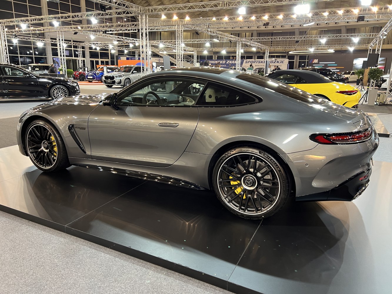 Gray coupe with black multi-spoke wheels and yellow brake calipers