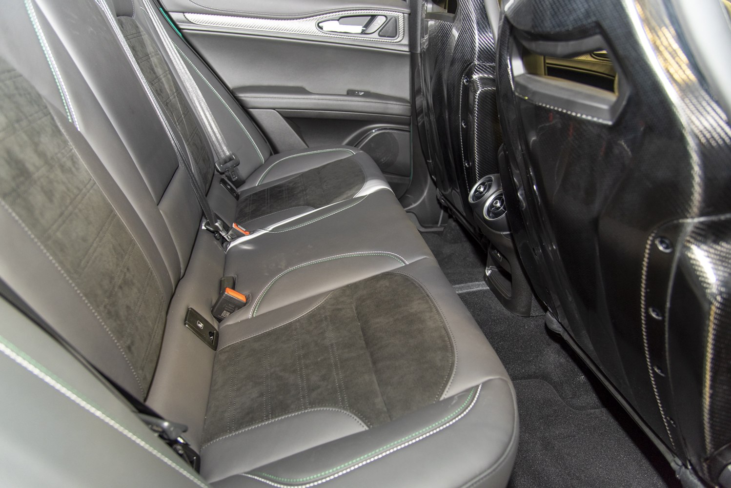 Rear leather seats with carbon fiber seatbacks and green stitching