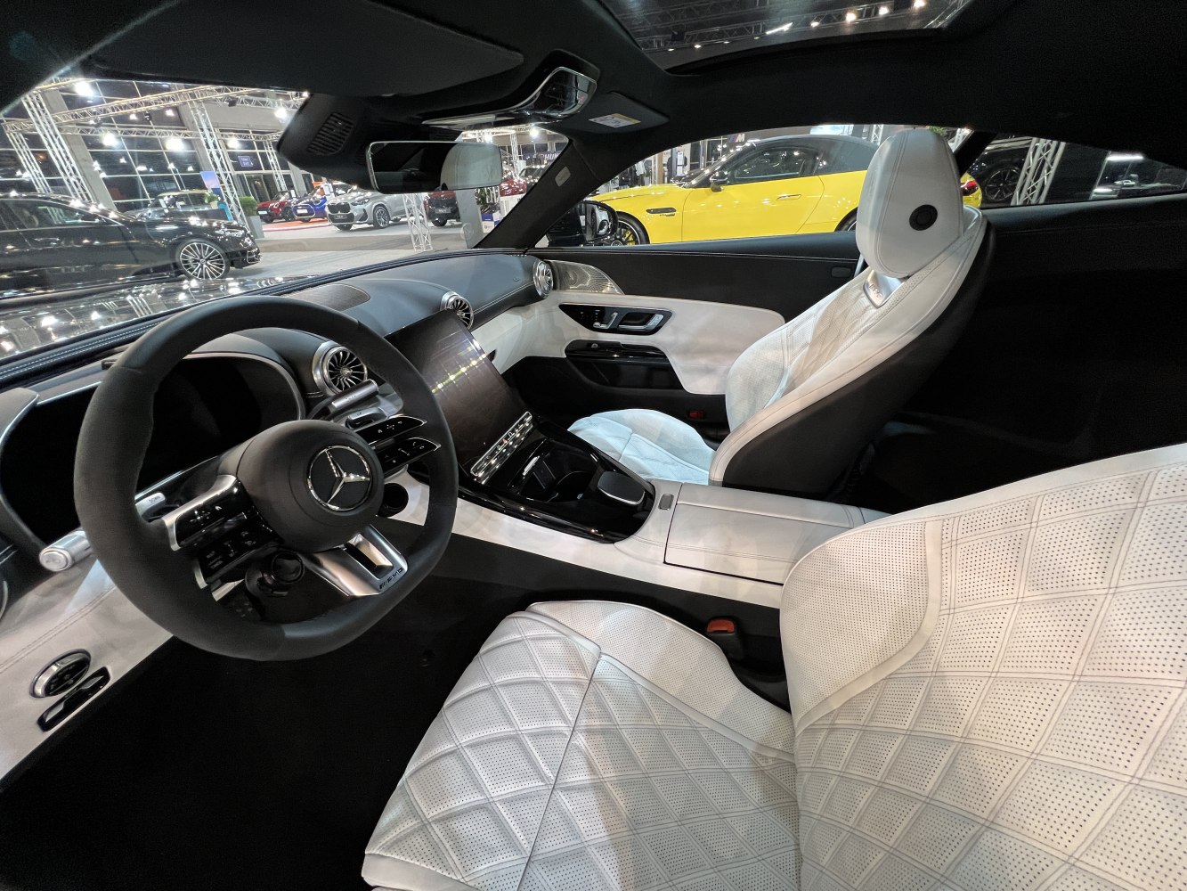 White quilted seats and advanced digital dashboard with sporty steering wheel.