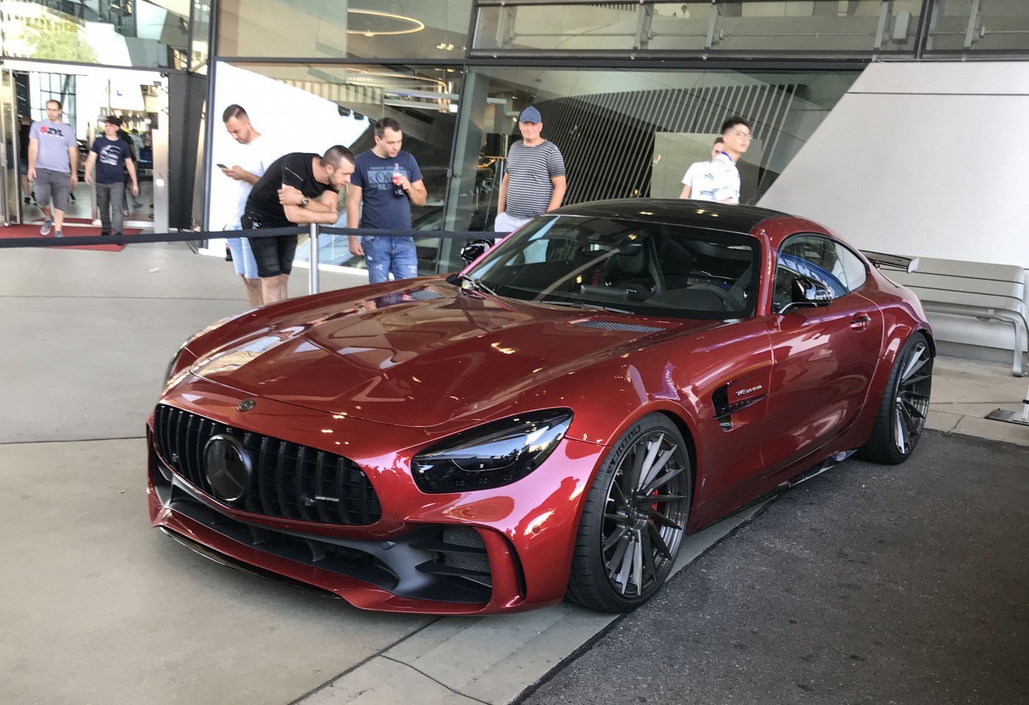Front-side view of a metallic red sports coupe with aggressive styling and dark multi-spoke wheels