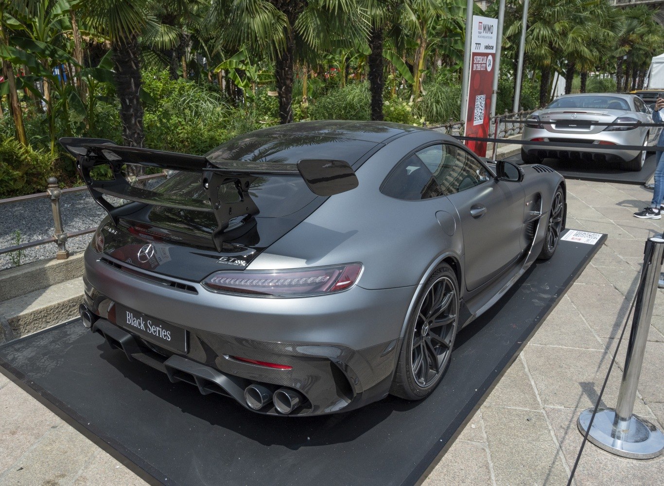 Carbon fiber large rear wing and quad exhausts on a matte sports coupe