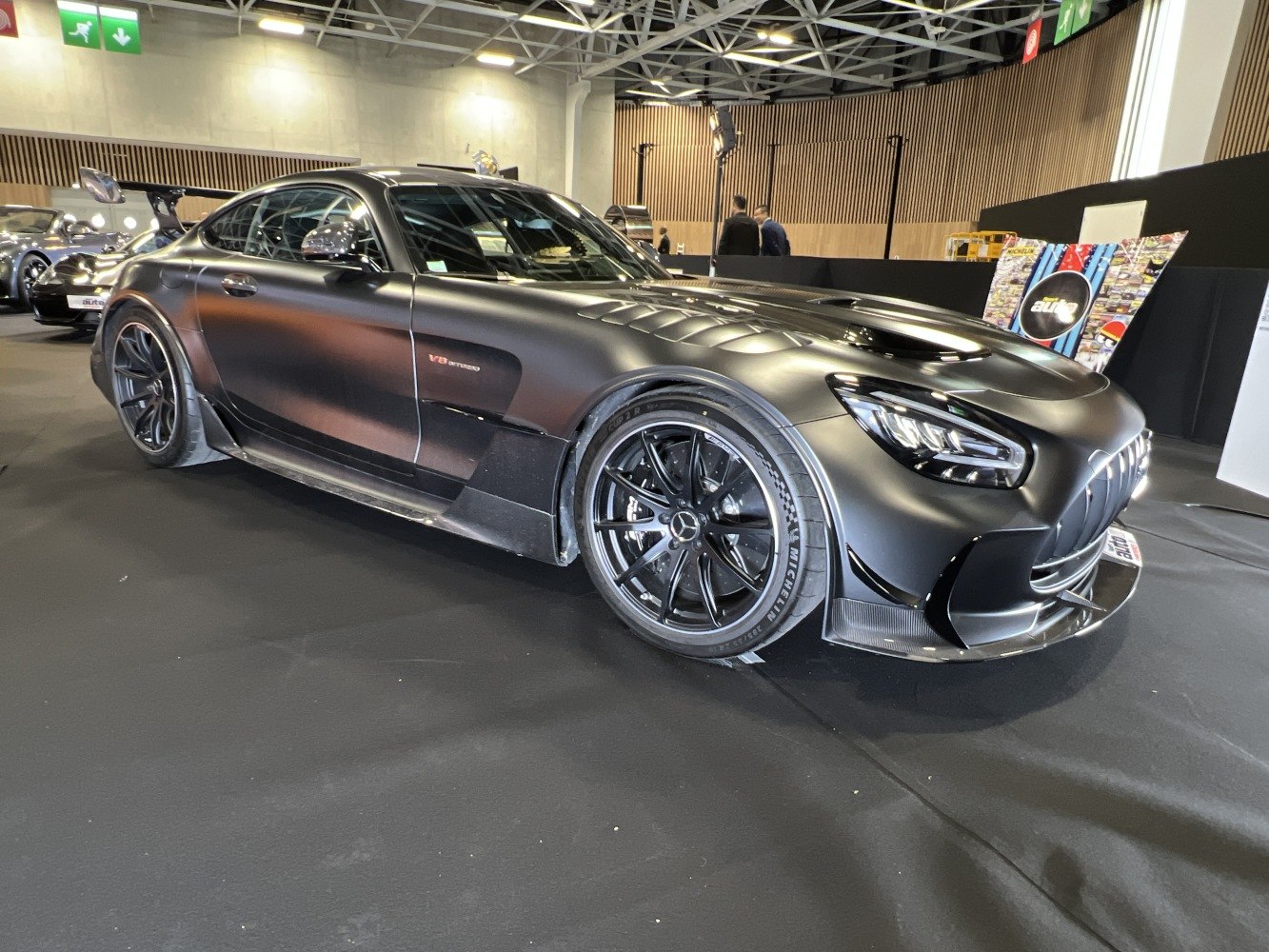 Matte black sports coupe with V8 Biturbo engine and aerodynamic front.