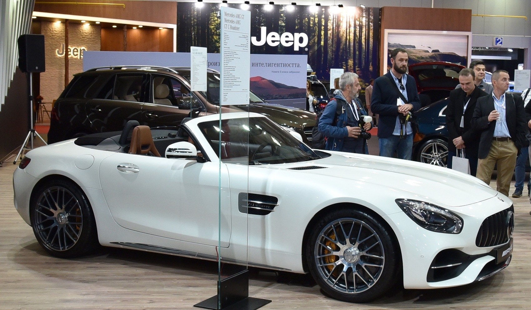 White convertible sports car with multi-spoke alloy wheels and aerodynamic front design.