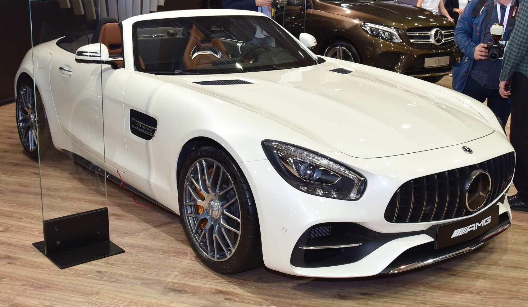Front grille, headlights, and alloy wheel of a white luxury roadster