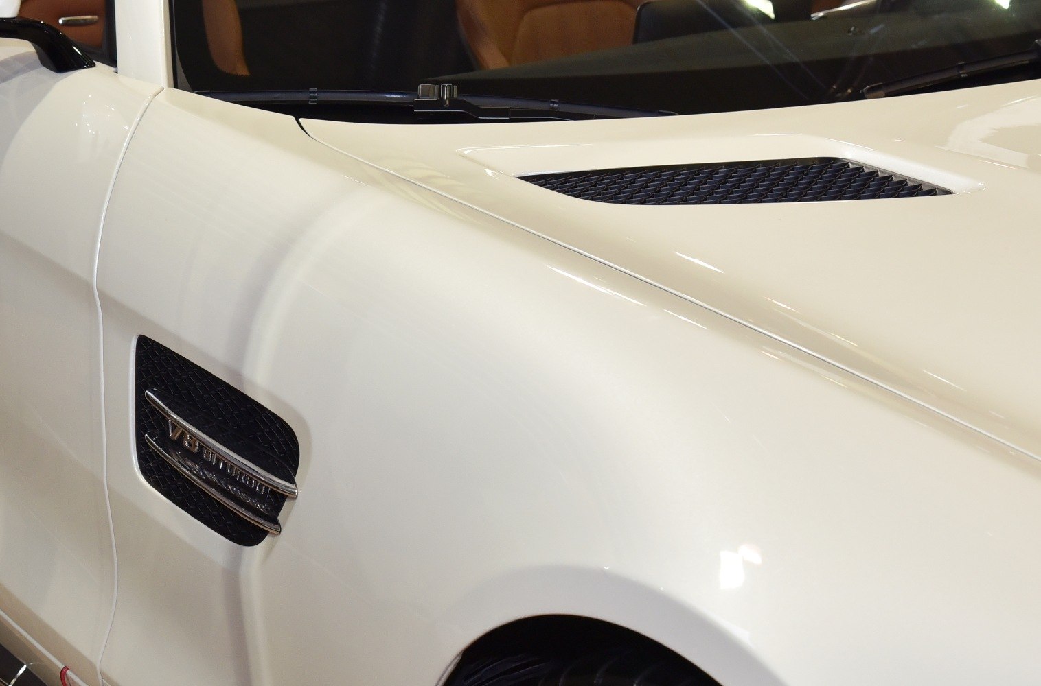 Close-up of hood vent and side vent grille on white luxury sports roadster