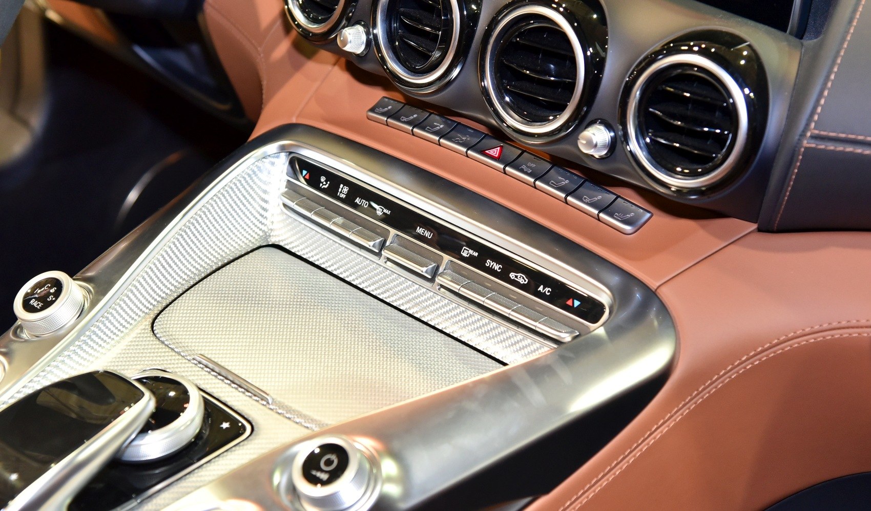 Luxury car interior with center console controls and circular air vents