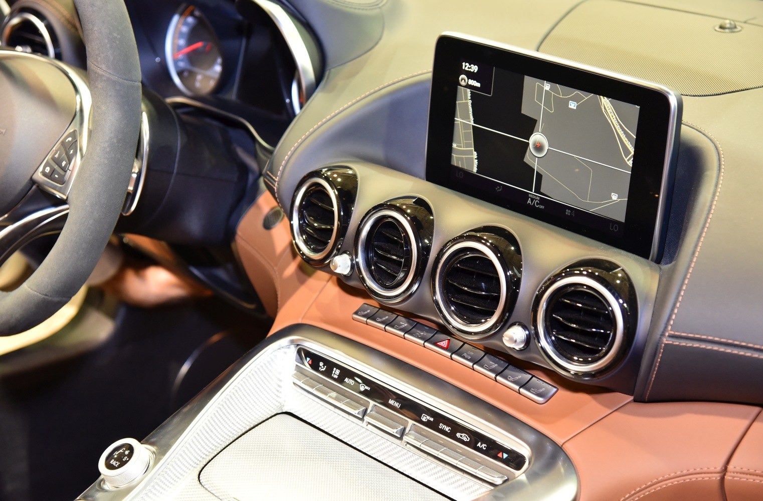 Digital navigation screen and four circular air vents in car interior