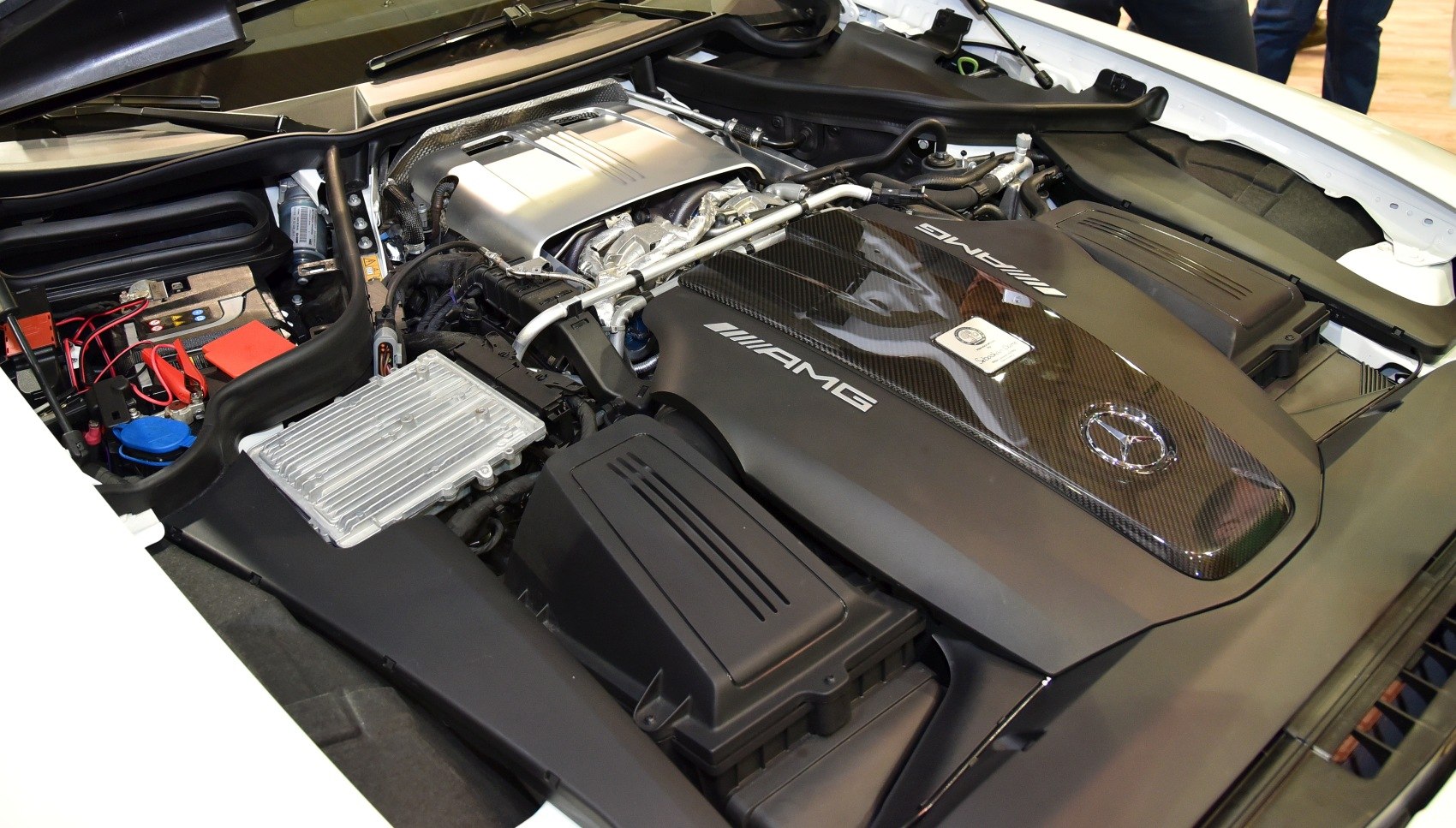 Close-up of AMG engine bay with carbon fiber cover and components