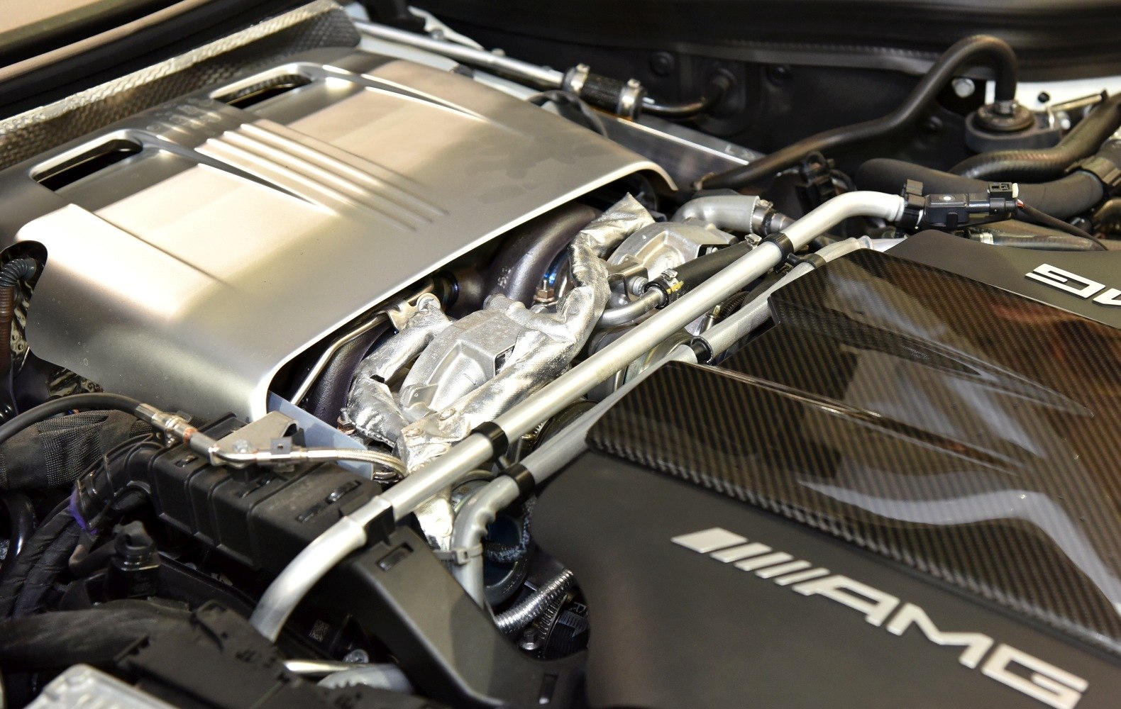 Close-up of AMG engine with carbon fiber cover and AMG branding