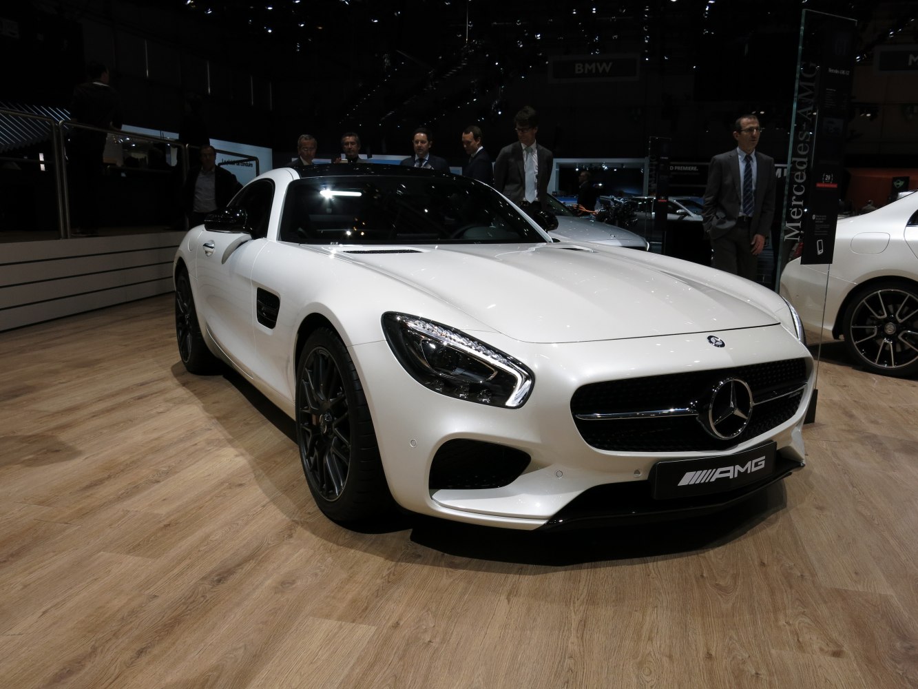Sleek white sports coupe front view with distinctive headlights and black wheels