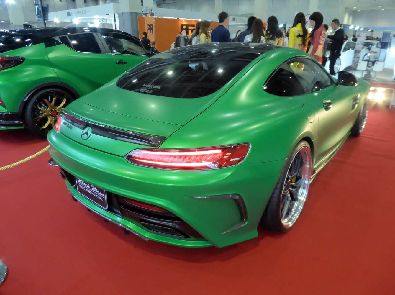 Rear view of a green luxury coupe with LED taillights and wide sport wheels