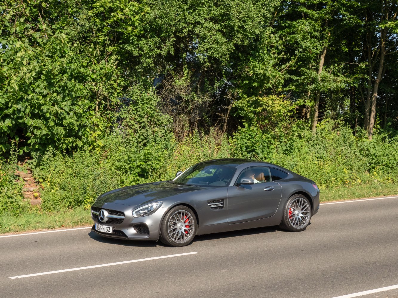 Grey coupe with sporty design, alloy wheels, and front side view on the road