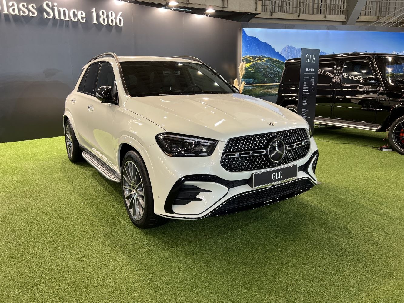 White luxury SUV with modern front grille and LED headlights.