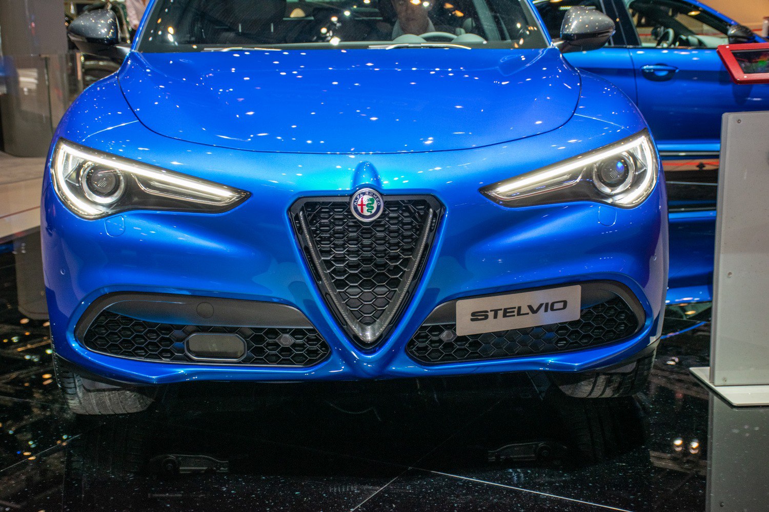 Iconic triangular grille and sharp LED headlights on front of a blue SUV.