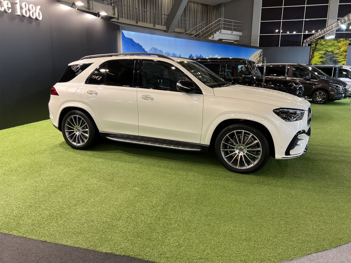 White luxury SUV with chrome multi-spoke wheels and roof rails