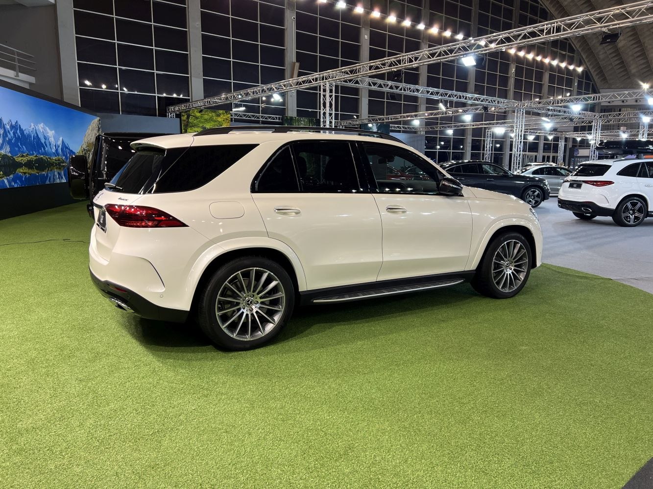 Rear three-quarter view of a white luxury SUV with sleek design and alloy wheels.