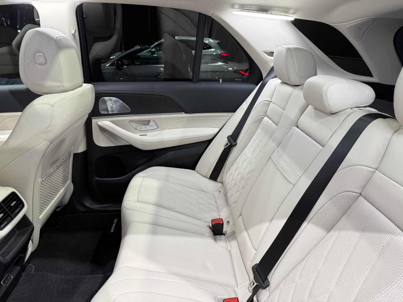 Luxury rear seats with light perforated leather upholstery and seat belts.