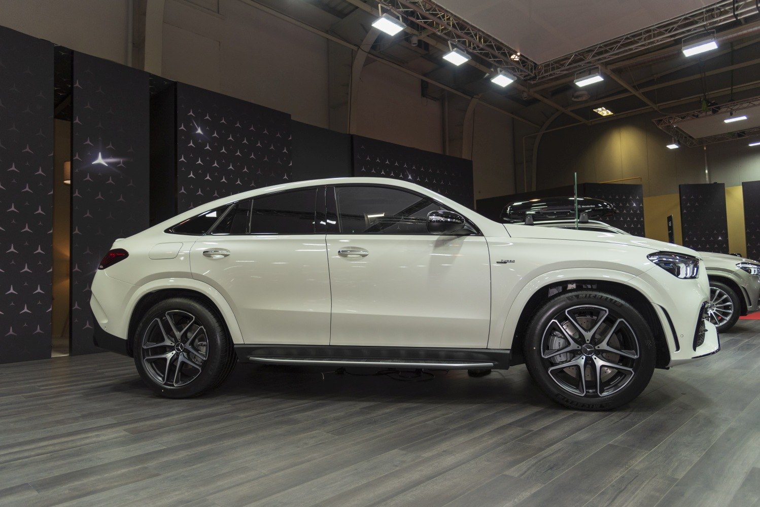 Side profile of sleek coupe SUV with sloping roofline and turbo badge