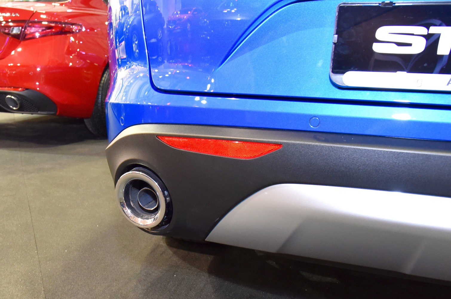 Close-up of rear bumper, exhaust pipe, and reflector