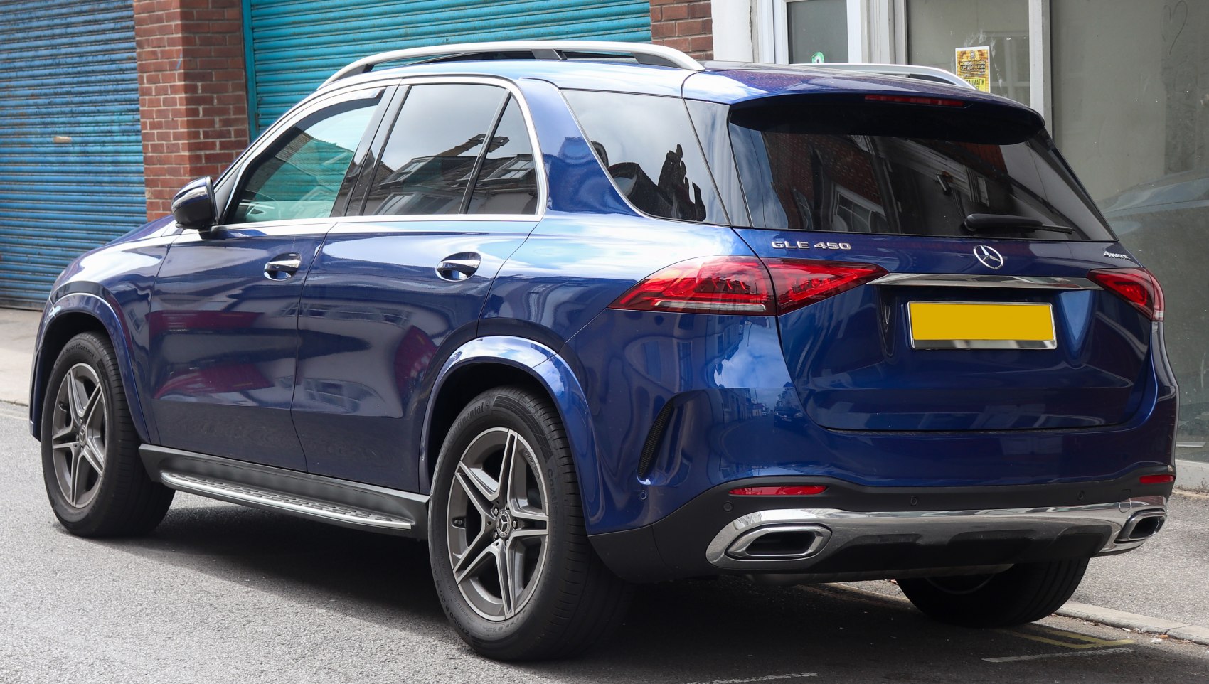 Blue SUV rear side view with distinct taillights and alloy wheels.