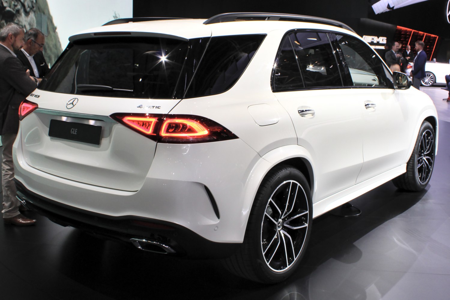 White luxury SUV rear with LED taillights and alloy wheels.