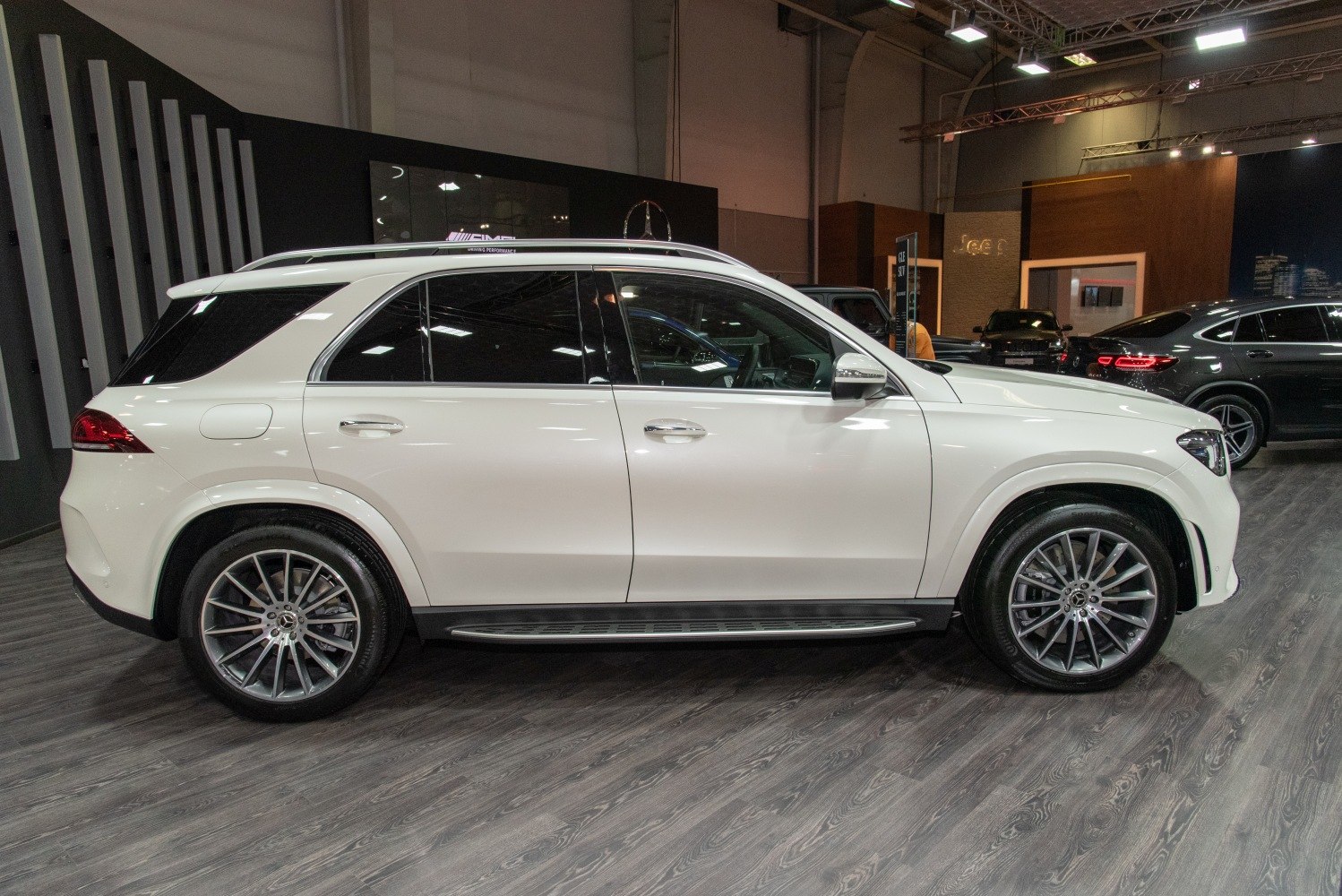 White luxury SUV side profile with alloy wheels and roof rails