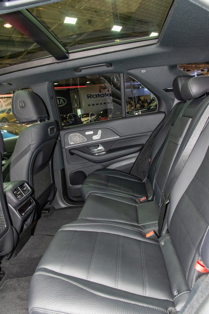Rear leather seating and panoramic glass roof in luxury SUV interior.