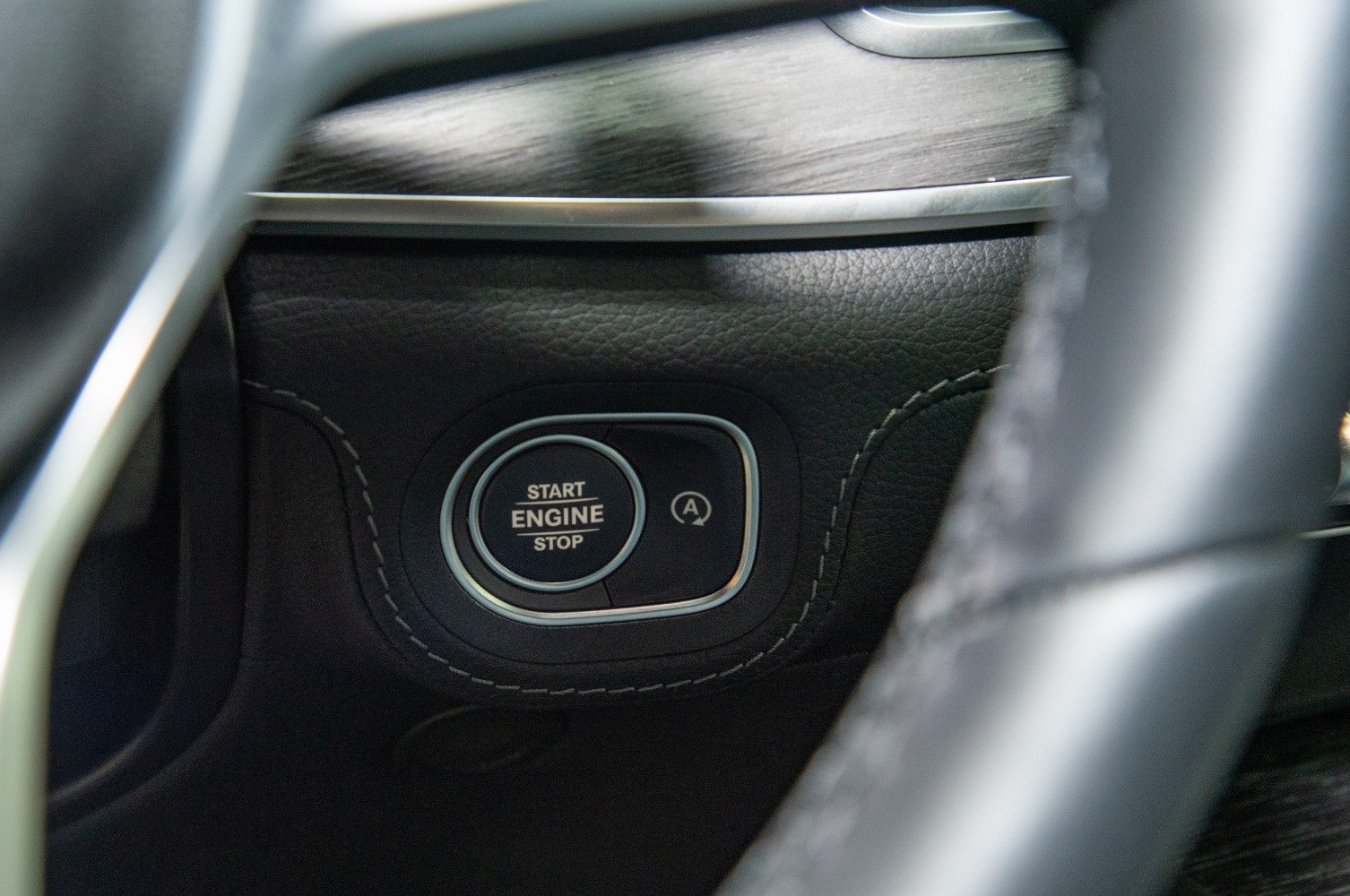 Engine start/stop button with leather and metallic trim detail