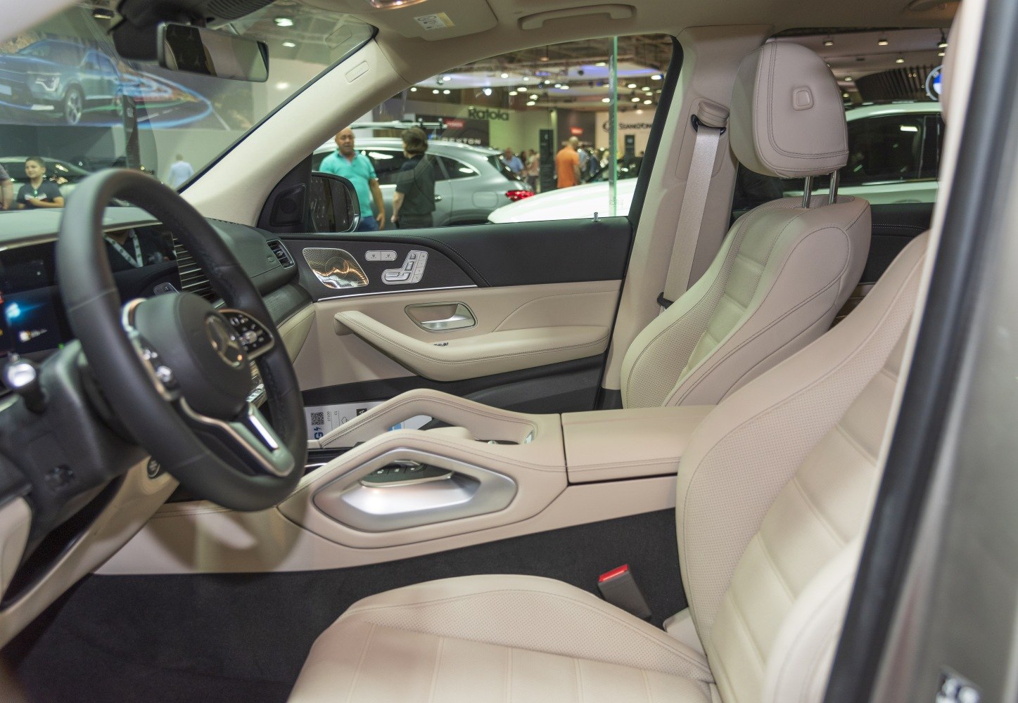Beige leather seats with plush armrest and detailed door panel controls