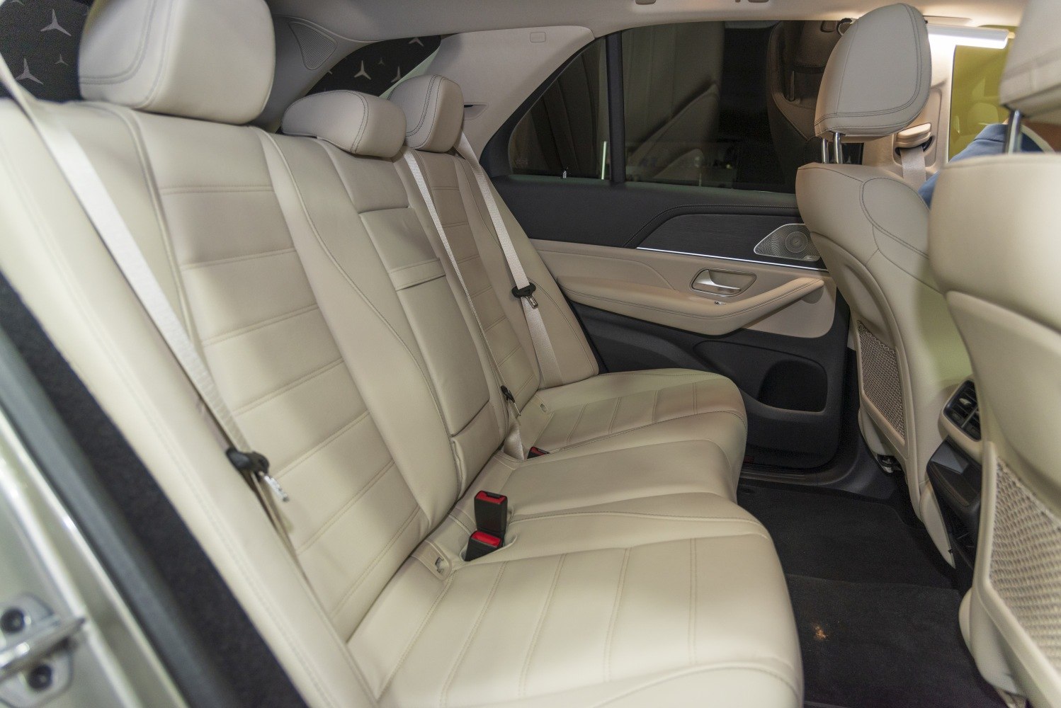 Beige leather rear passenger seats with spacious legroom and modern door panel