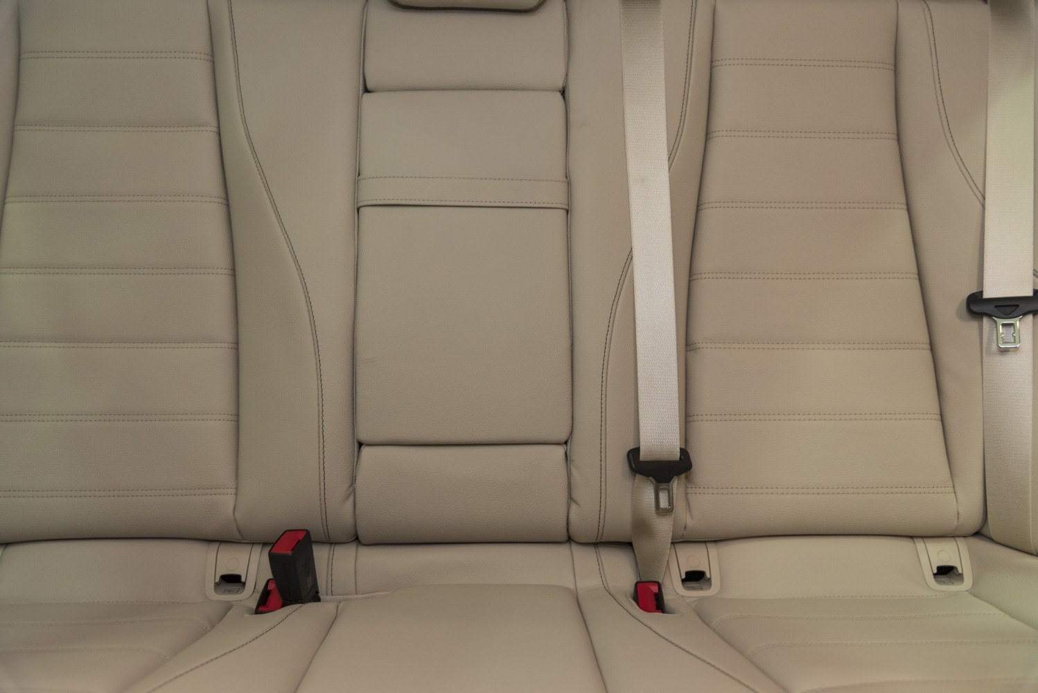 Beige leather rear seats with seat belts and center armrest