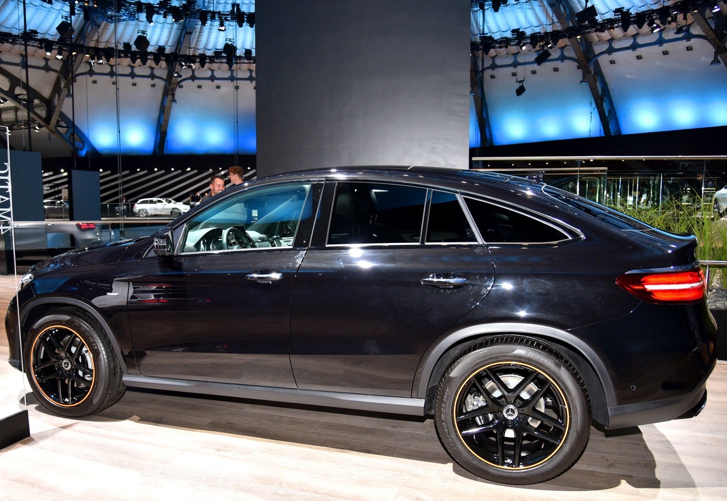 Side profile of a coupe-style SUV with distinctive black and gold alloy wheels.