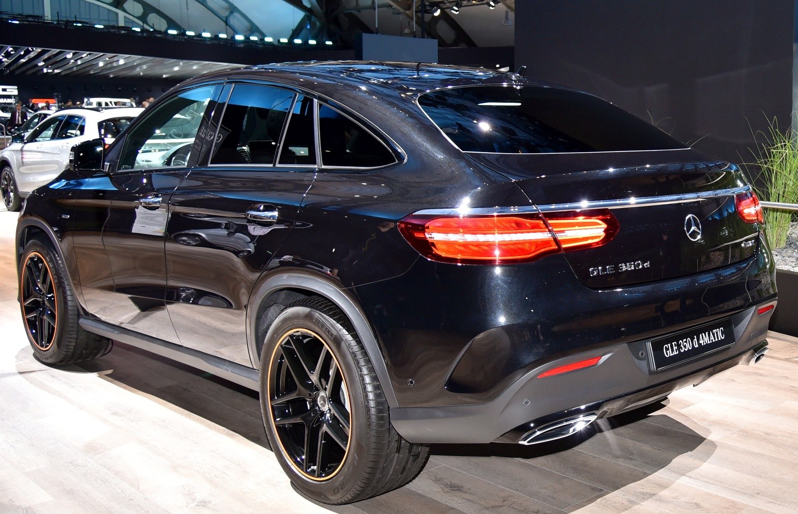 Rear and side profile of a luxury SUV with distinctive taillights and black alloy wheels.