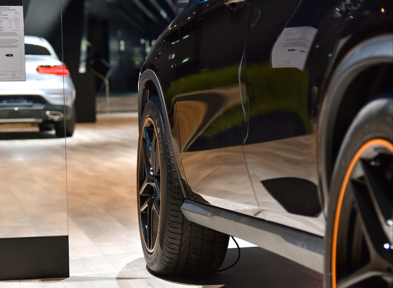 Black wheel with orange rim and reflective side panel on car