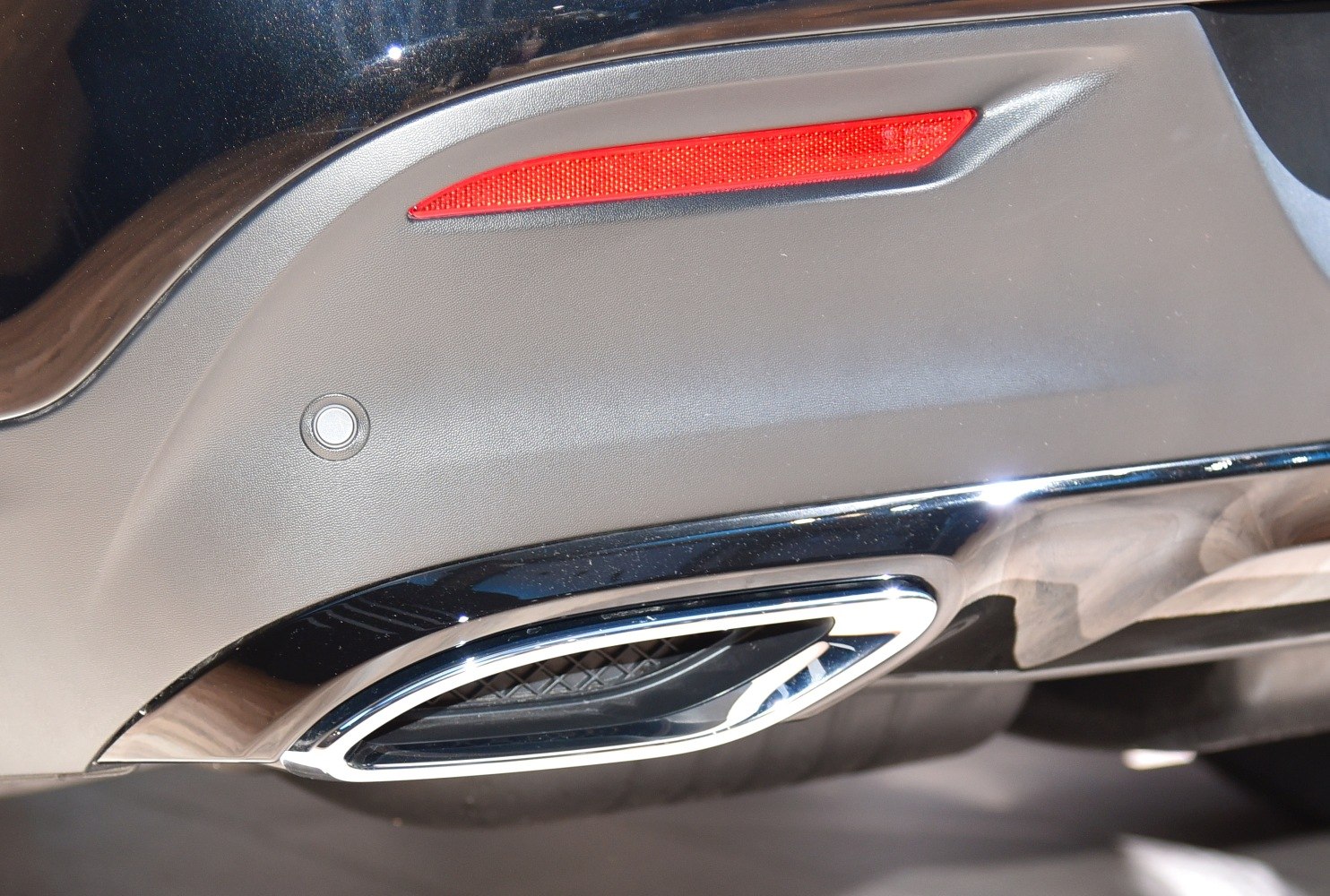 Rear reflector and chrome exhaust tip on vehicle's rear bumper