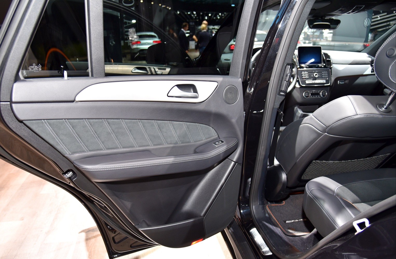 Luxury SUV interior door panel and rear leather seating with dashboard view
