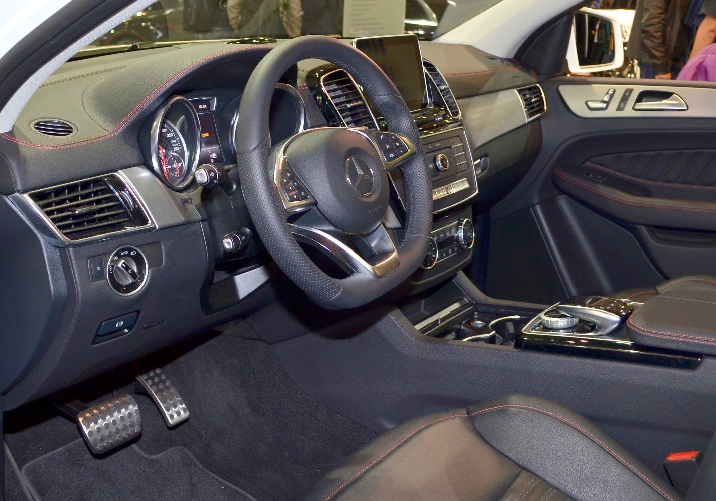 Luxury car interior with multifunction steering wheel and digital console.