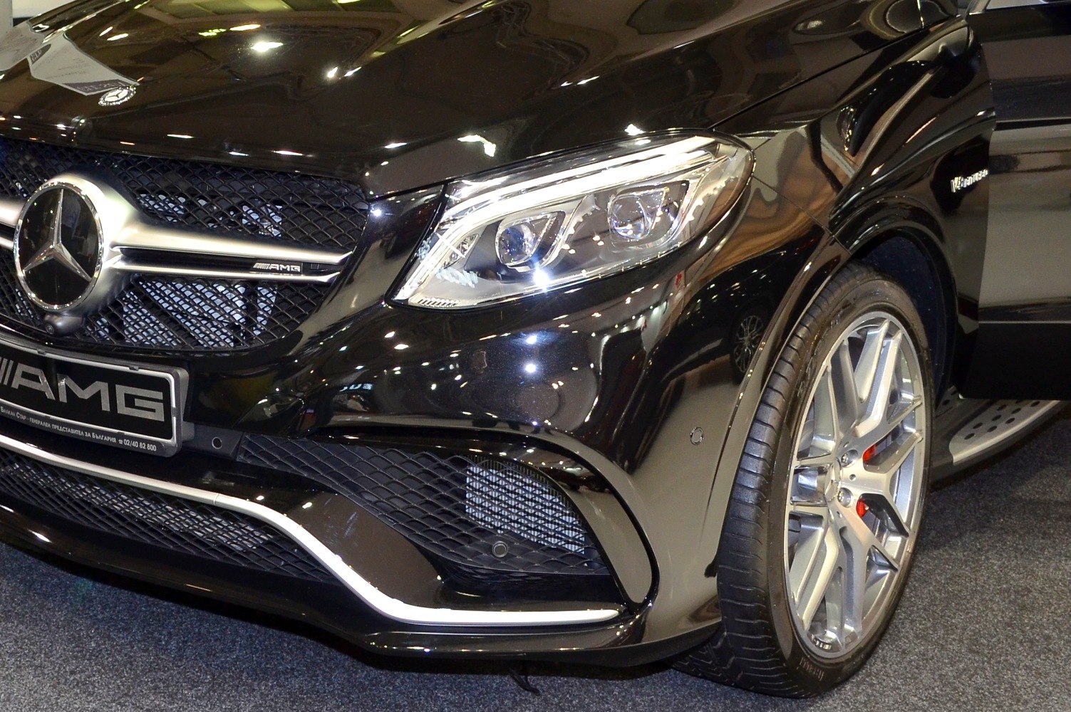 Close-up of front grille, headlight, and alloy wheel of a luxury SUV