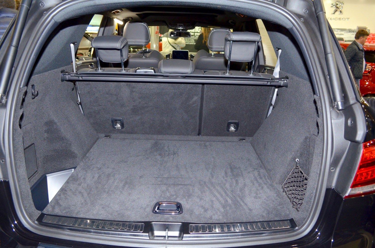 Large carpeted SUV cargo space with rear seats and toggle cover