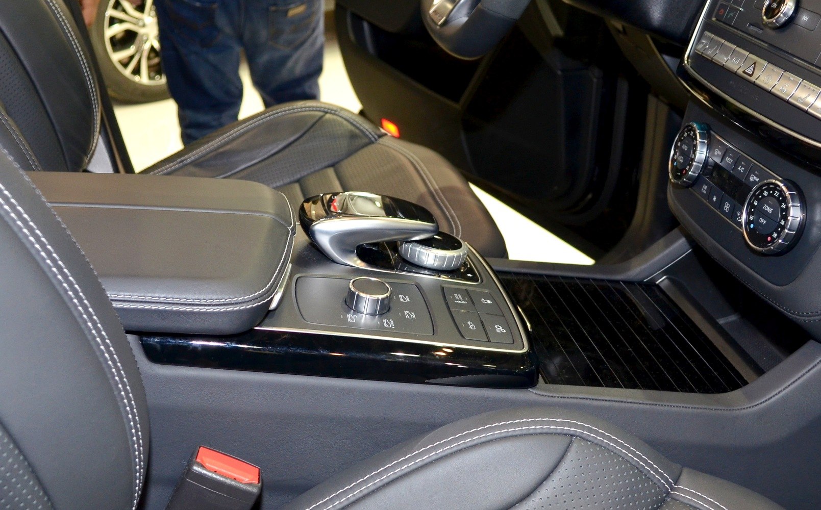 Close-up of center console controls and leather armrest in car interior
