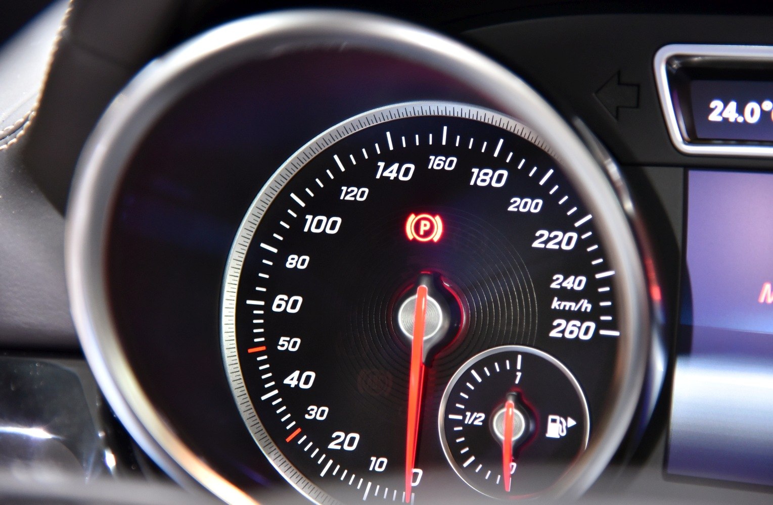 Close-up of speedometer and fuel gauge with illuminated indicators
