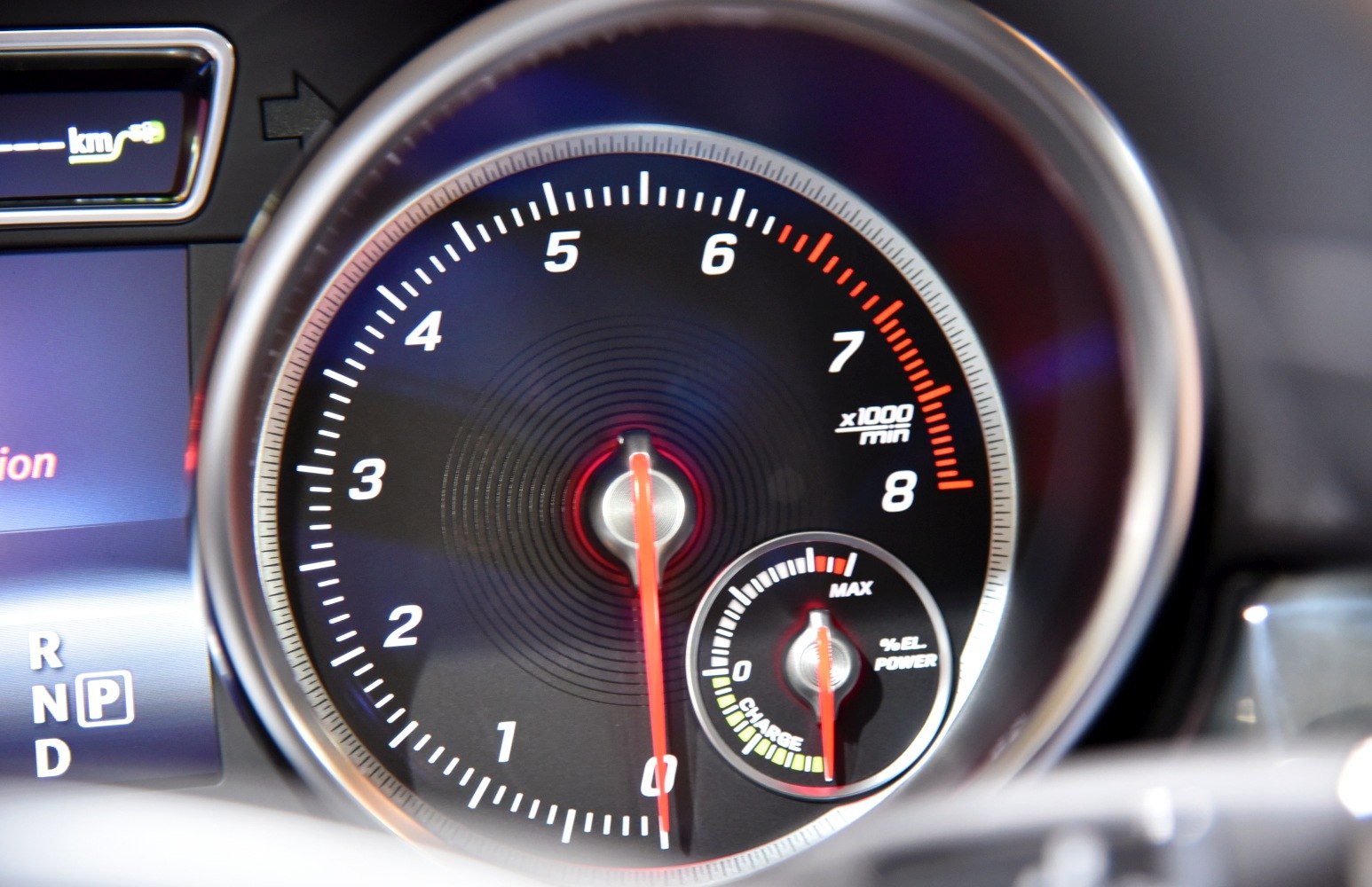 Close-up of tachometer and electric power gauge in car instrument cluster