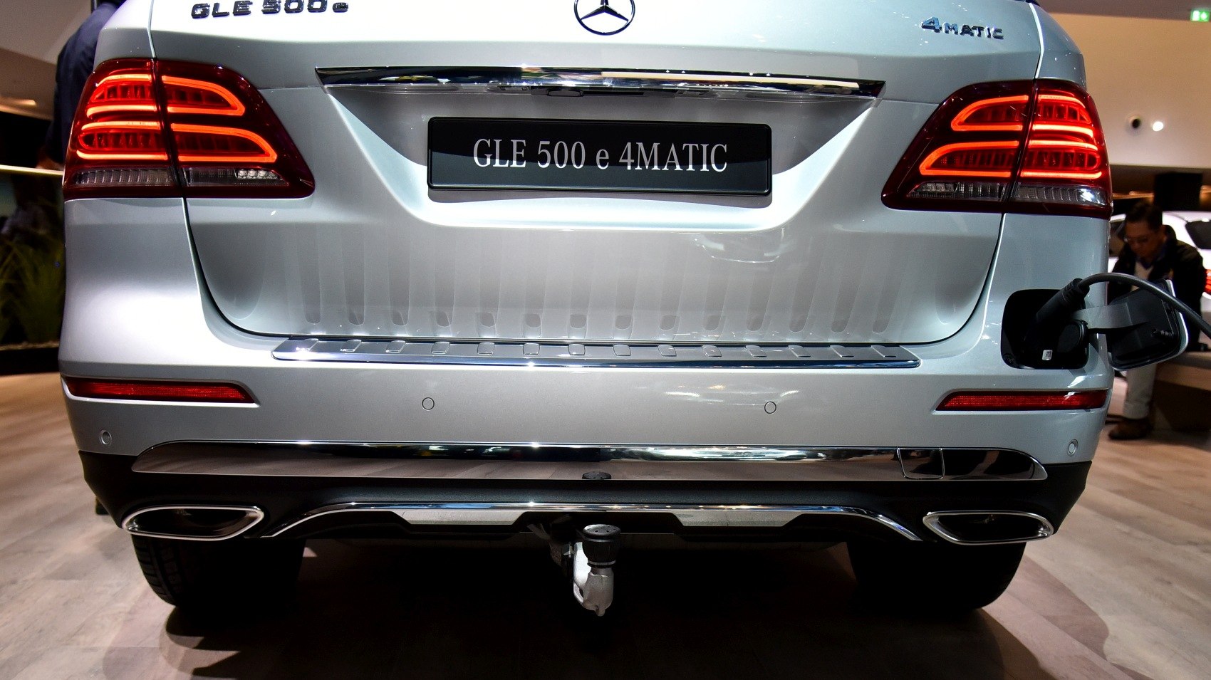 Rear view showing taillights, twin exhausts, tow hitch, and charging port