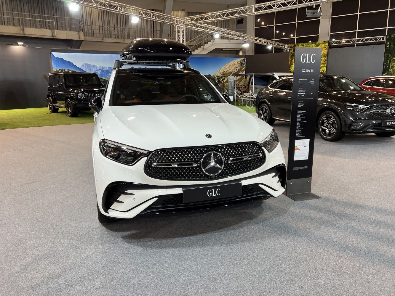 Front view of white SUV with luxury grille and roof cargo box