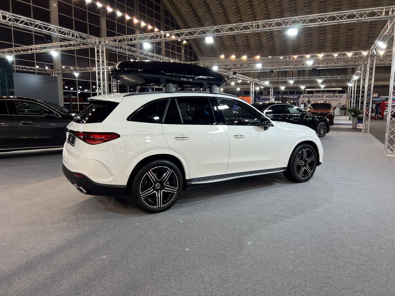 White SUV with black roof cargo box and stylish alloy wheels