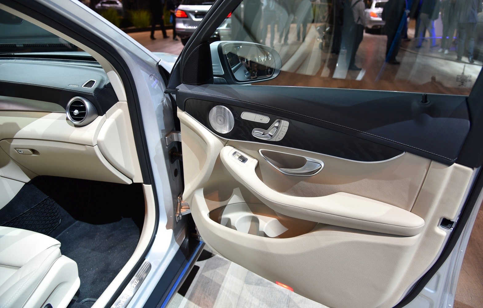 SUV door panel with speaker and seat adjustment controls in beige leather