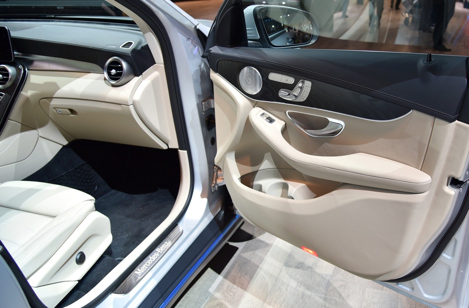 Beige interior door panel and dashboard with controls and premium finishes